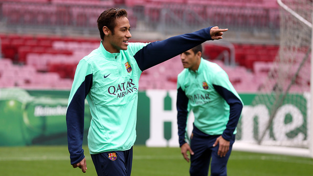 Neymar aixeca el braç i somriu durant l'entrenament al Camp Nou